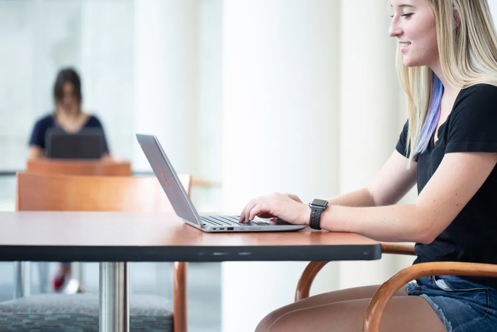 student using her chromebook on campus